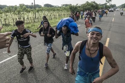 Um grupo de jovens encoraja um migrante idoso a seguir na caminhada para Tapachula.