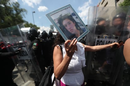 Araceli Osorio muestra una foto de su hija Lesvy, asesinada por su novio, en las marchas del 8M de 2022, en México. 