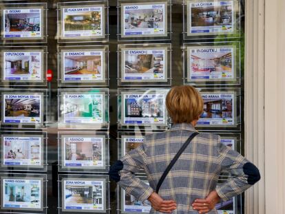 Una mujer mira la oferta de viviendas en una inmobiliaria.