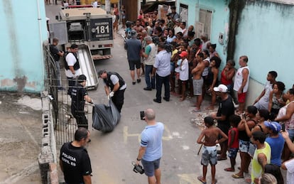 Moradores de Vitória observam a Polícia Civil retirar um corpo em uma rua no Espírito Santo, nesta sexta-feira.