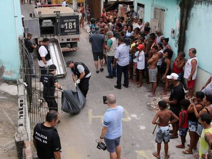 Moradores de Vitória observam a Polícia Civil retirar um corpo em uma rua no Espírito Santo, nesta sexta-feira.