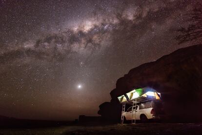 Una tienda de campaña instalada sobre el techo de una furgoneta en Namibia. En el cielo se puede ver la Vía Láctea. 