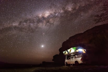 Una tienda de campaña instalada sobre el techo de una furgoneta en Namibia. En el cielo se puede ver la Vía Láctea. 