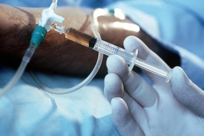 Un sanitario inyecta a una persona un líquido por un vial.