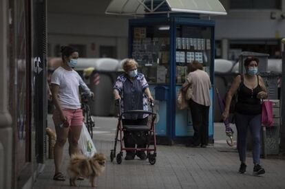 Diverses persones passegen per un carrer de Barcelona.