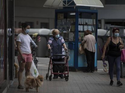 Diverses persones passegen per un carrer de Barcelona.