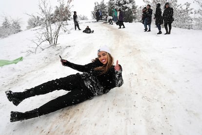 Una mujer iraní se desliza en la nieve en un parque de Teherán, el 12 de febrero de 2023.