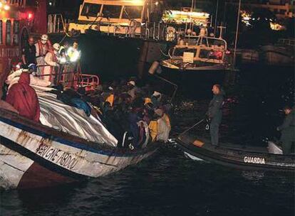 El sexto cayuco que llegó ayer, con 120 inmigrantes, atraca en el puerto de Los Cristianos de Tenerife.