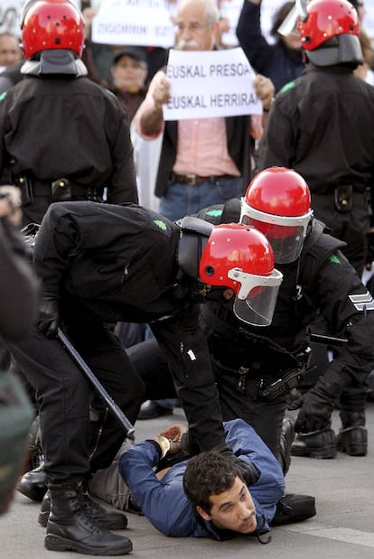 Dos<i> ertzainas</i> reducen a un manifestante.