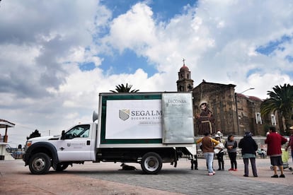 Un grupo de personas hacen fila para comprar en una tienda móvil de Segalmex.