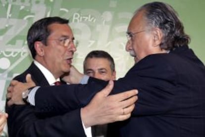 El presidentedel PNV, Iñigo Urkullu, observa el abrazo entre el alcalde de Bilbao Iñaki Azkuna, a la derecha, y el diputado general de Vizcaya José Luis Bilbao.