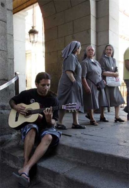 Un músico toca la guitarra en uno de los accesos a la plaza Mayor.