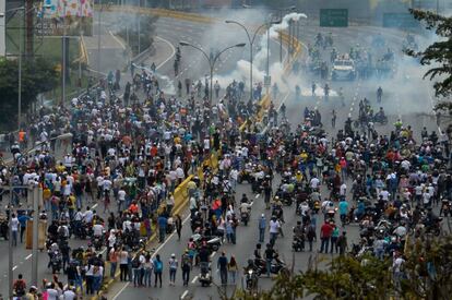 Los manifestantes contrarios al Gobierno venezolano se enfrentan a la policía durante las protestas contra Nicolás Maduro en Caracas.
