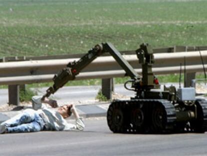 Un terrorista suicida herido es examinado por un robot de desactivación de explosivos. PLANO GENERAL - ESCENA