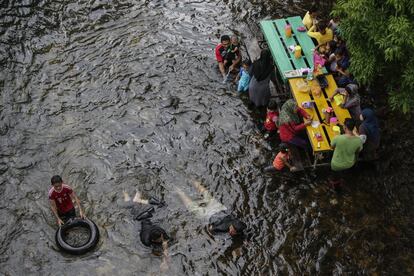 Un grupo de personas almuerza en el Café Castella, en el río Beruk, en Gerik, Perak, a unos 450 km de Kuala Lumpur (Malasia). 