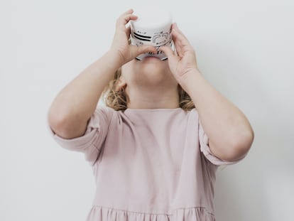 Una niña bebe un vaso de leche.