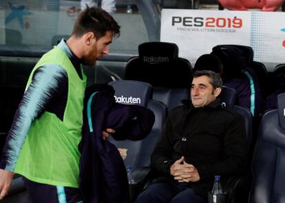 Lionel Messi pasa ante Ernesto Valverde para sentarse en el banquillo.