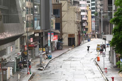 Un peatón cruza una calle vacía en el distrito comercial de Central, mientras Hong Kong se prepara por segunda vez en menos de una semana a recibir un ciclón tropical.