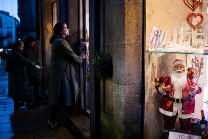 Varias personas observan el escaparate de una tienda, este miércoles en Santiago.