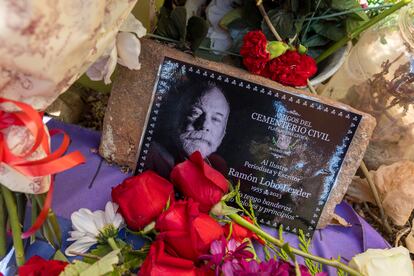 Una fotografía de Ramón Lobo, rodeada de flores en la placa que homenajea a Las Trece Rosas en el cementerio de La Almudena de Madrid.