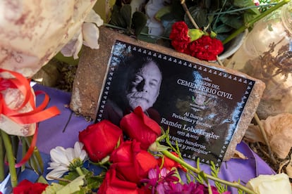 Una fotografía de Ramón Lobo, rodeada de flores en la placa que homenajea a Las Trece Rosas en el cementerio de La Almudena de Madrid.