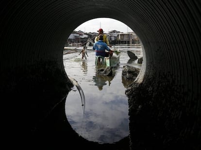 Pescadores filipinos preparan las redes de pesca junto a una ca&ntilde;er&iacute;a de aguas residuales en una zona pesquera de Bacoor (Filipinas).