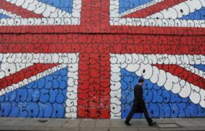 Un hombre pasa por delante de un grafiti gigante con la bandera del Reino Unido, en Londres. EFE/Archivo