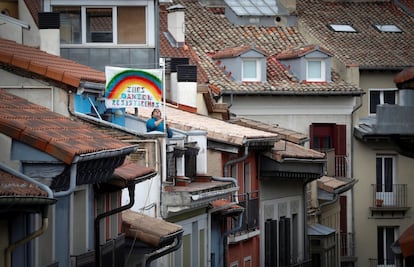 Una persona coloca en su terraza el dibujo de un arcoíris solidario con los nombres de sus hijos en el casco histórico de Pamplona.