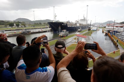 Varias personas observan el paso de un barco por una sección de las esclusas Miraflores del canal de Panamá este lunes, en Ciudad de Panamá (Panamá). 