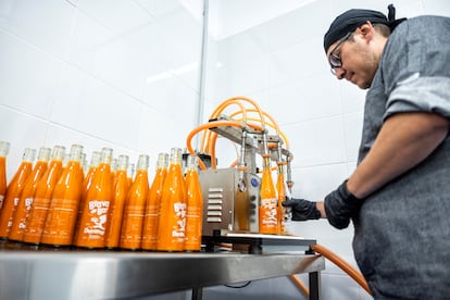 En la imagen, Walter Erazo se encarga de cerrar las botellas antes de su pasteurización para una mejor conservación.