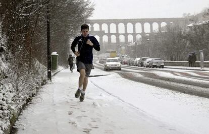 Un joven corre sobre la nieve caída en la capital segoviana.