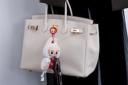 Un Labubu cuelga de un bolso de Hermés en una subasta de estos muñecos celebrada en Pekín el pasado 10 de junio. 