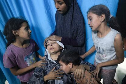 Una mujer rodeada por sus hijos esperaban a ser atendidos en el hospital Nasser en Jan Yunis, este lunes.
