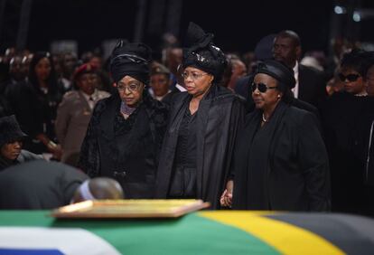Winnie Mandela, exesposa de Nelson Mandela y su viuda Graca Machel, junto al féretro del líder sudafricano durante la ceremonia.
