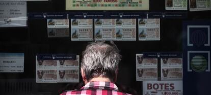 Una mujer frente a la ventanilla de una administración de lotería.