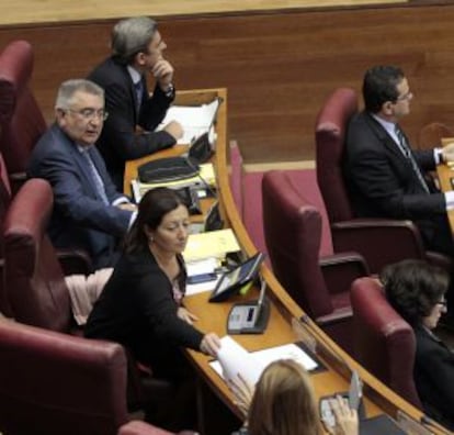 La diputada Maritina Hernández (izquierda) pasa a Trinidad Miró el escrito de apoyo al exalcalde de Torrevieja, mientras su compañero Fernando Giner contempla la escena desde su escaño.