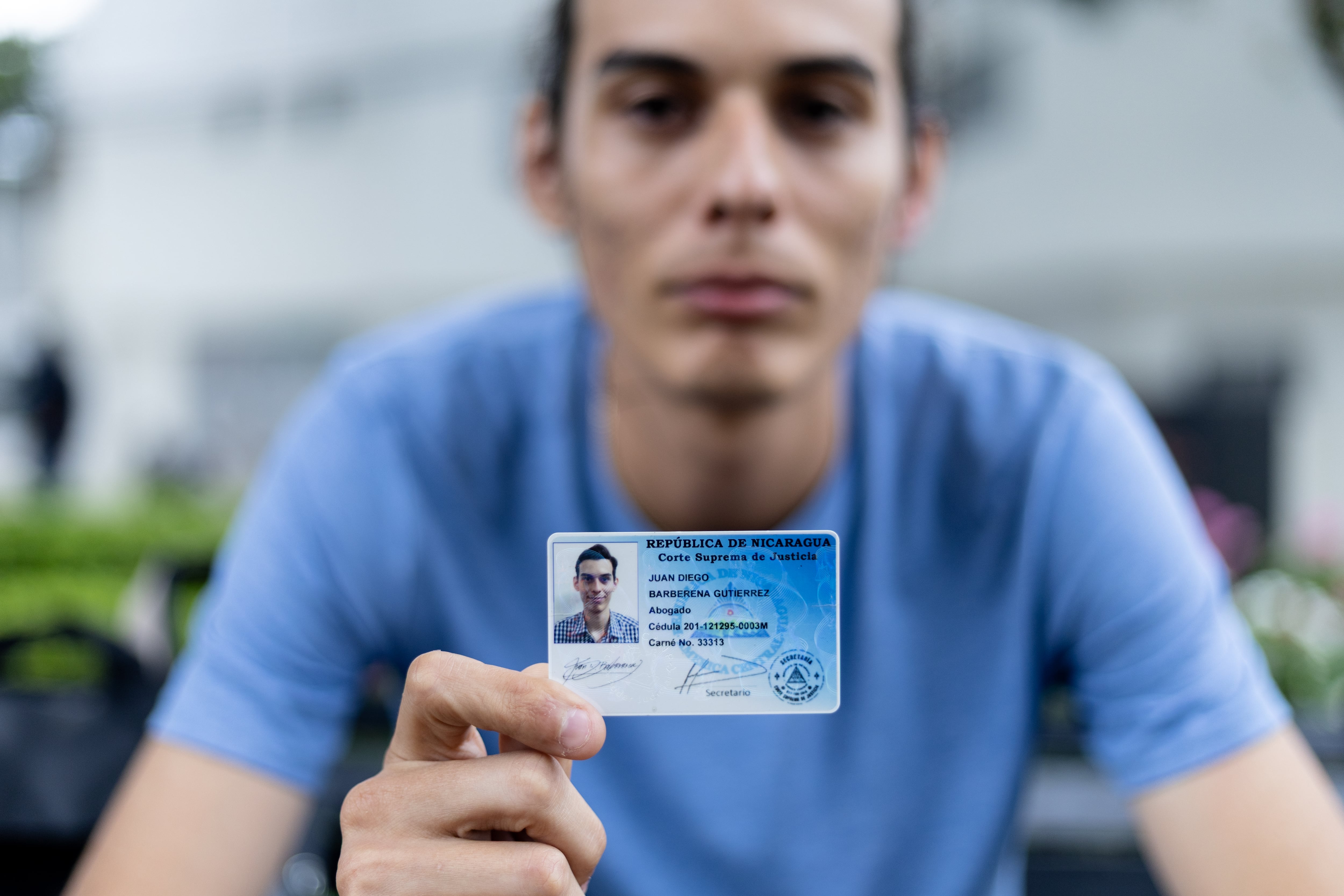 Juan Diego Barberena muestra su carnet de identidad profesional cancelado, este viernes.