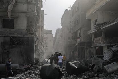 Palestinos inspeccionan una zona destruida tras los ataques aéreos israelíes en la ciudad de Gaza, este lunes.