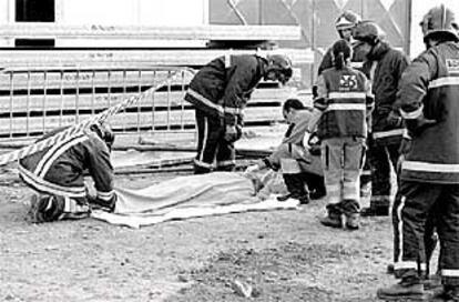 Bomberos de Sevilla cubren el cuerpo de un hombre muerto en febrero por accidente laboral.