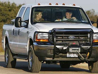 Angela Merkel, George Bush y Laura Bush (detrás), ayer en coche por el rancho de Crawford (Tejas).