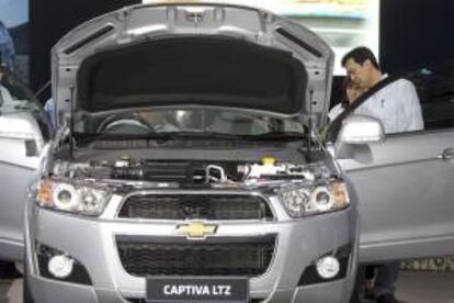 Varios clientes potenciales revisan un Chevrolet Captiva expuesto en un concesionario. EFE/Archivo