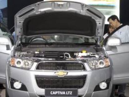 Varios clientes potenciales revisan un Chevrolet Captiva expuesto en un concesionario. EFE/Archivo