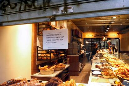 Un puesto del mercado de la Boquería de Barcelona informa a sus clientes de que cerrará por la tarde en apoyo a la huelga general que Cataluña vive este viernes.