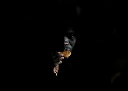 Un migrante come una galleta en la nave de la estación de ayuda de migrantes después de ser rescatado cerca de la costa de Libia.