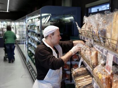 Un empleados repone los productos de panader&iacute;a en un supermercado