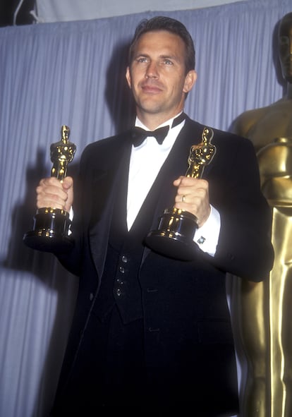 Kevin Costner holds the Oscars for Best Picture and Best Director, which he won for 'Dances with Wolves.'