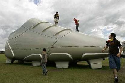 Un grupo de jóvenes se encarama a un bota gigante en Berlín.