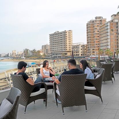 Unos jóvenes en un hotel de Famagusta, en el norte de Chipre, ocupado por Turquía. Al fondo, Varosha, un distrito turístico griego abandonado desde 1974.
