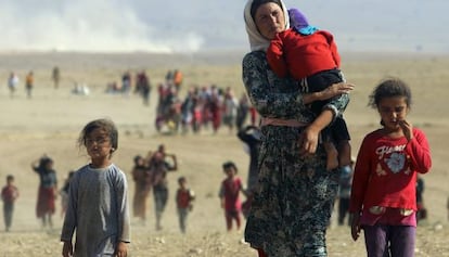 Desplazados yazid&iacute;es abandonan la ciudad de Sinjar, en agosto.
