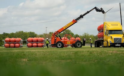 Desde la semana pasada, el Gobierno dirigido por el republicano Greg Abbott comenzó a trasladar boyas naranjas de grandes dimensiones a la frontera entre Eagle Pass y Piedras Negras. En la imagen, un grupo de operarios descarga boyas de un camión, en Eagle Pass, el pasado 7 de julio. 